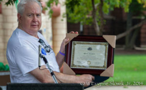 Owner Bruce Nesbitt holds up his certificate of recognition