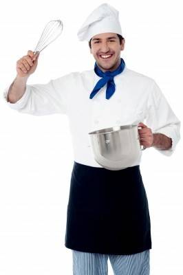 A chef with mixing bowl and whisk